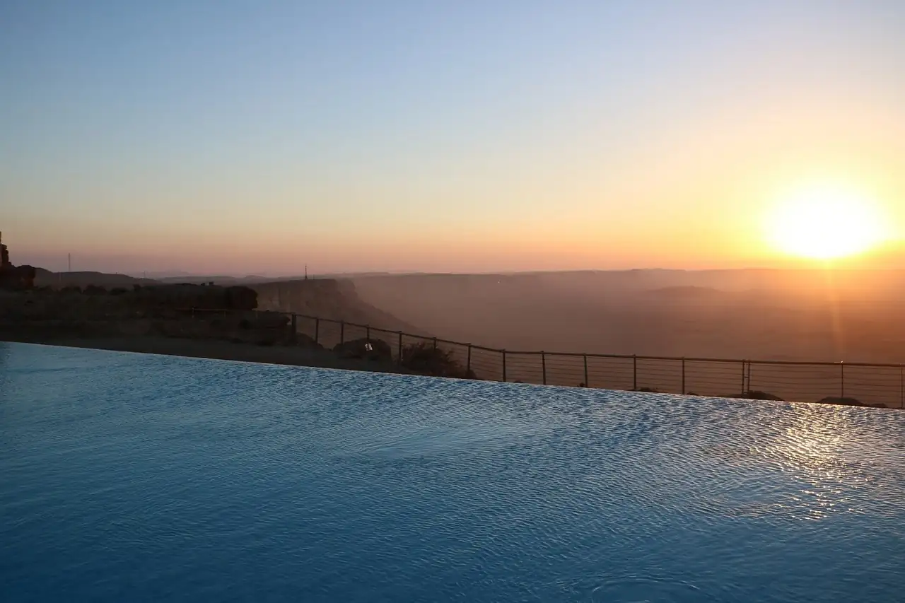 Hotel infinity pool at sunset overlooking hills