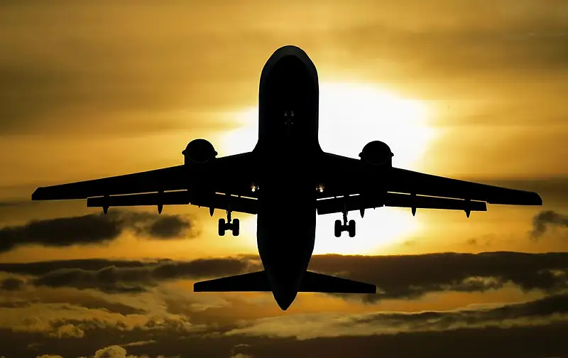 Passenger plane silhouette against a golden sunset